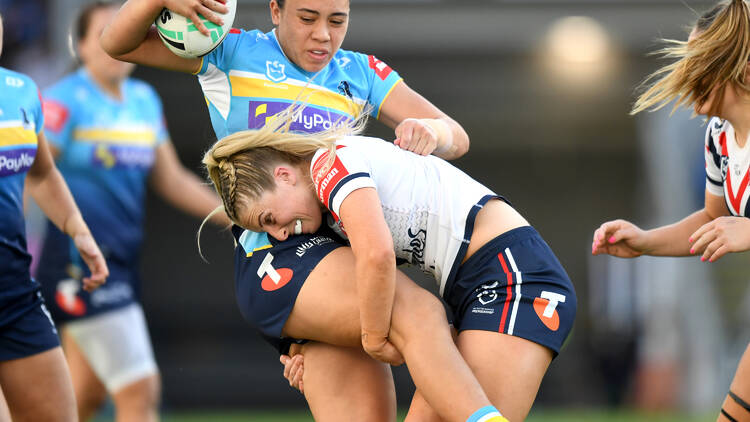 A female football player tackling another female footballer