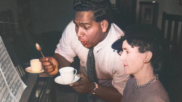 Harold Blair singing at a piano with a female pianist