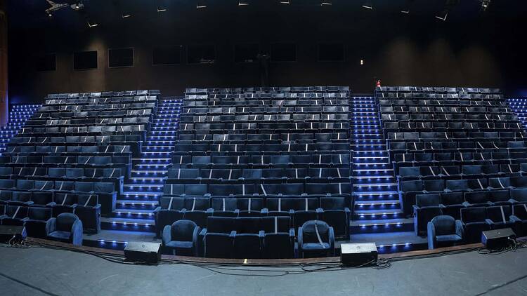 Plateia do Teatro Prudentia com luz azulada, separada por duas escadas