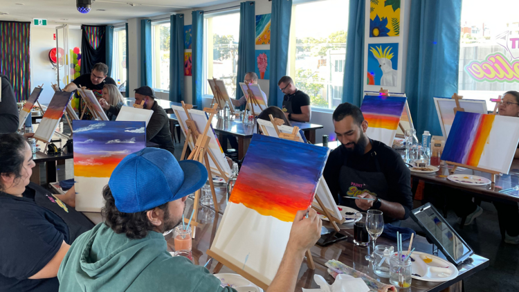 A painting class with students painting a sunset