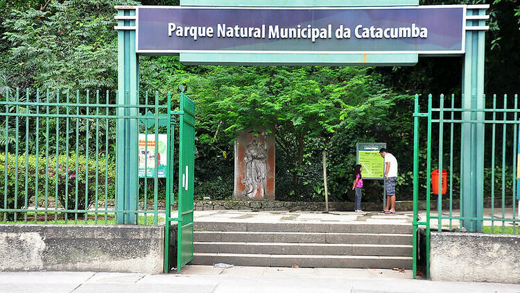 Entrada do Parque da Catacumba com grades verdes e uma escada pequena
