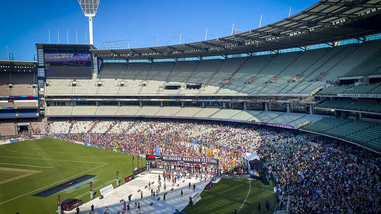 The MCG grounds filled with people as runners cross the finish line. 