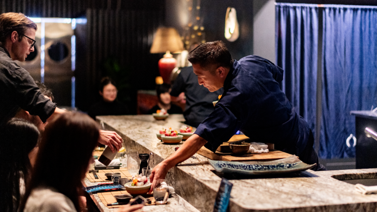 Nobuyuki Ura passing a plate to a guest