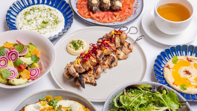 A brunch spread with kebabs, salads and dips