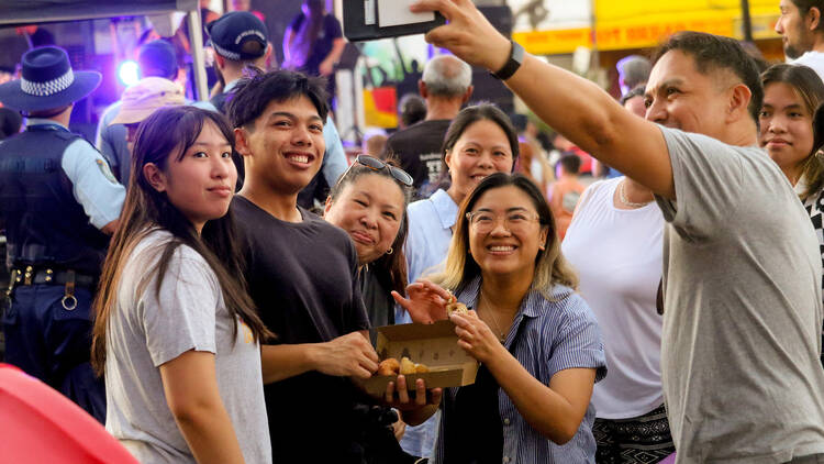 A family posing for a selfie at a night market