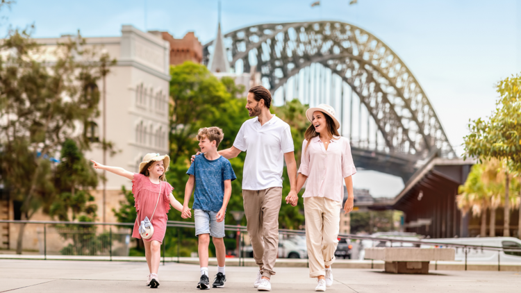 A family walking in front of the harbour bridge