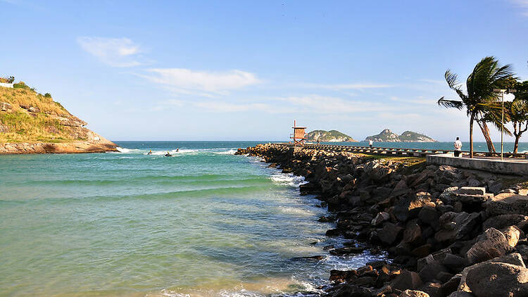 Um pier de pedras dá início às águas da Praia da Barra