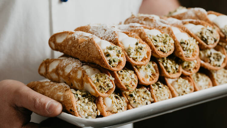 A plate of freshly filled ricotta cannoli.