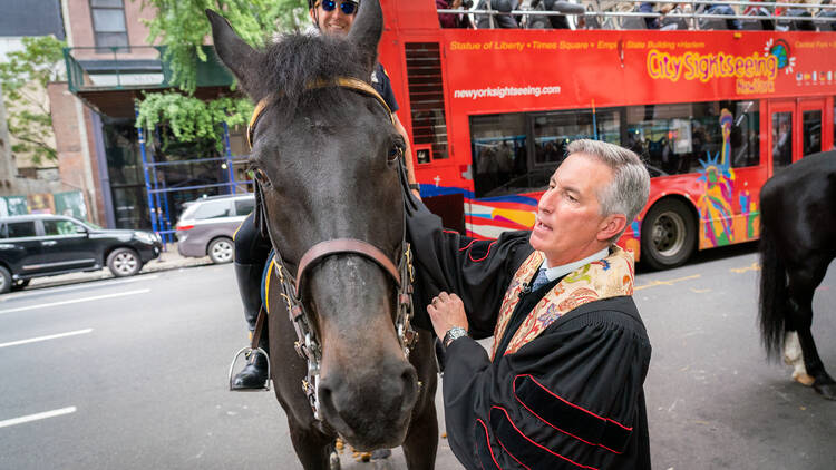 Marble Church Sr. Minister Dr. Michael Bos blesses an equine member of the NYPD Mounted Unit.