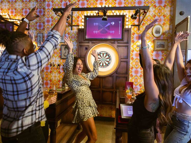 People celebrating while playing darts