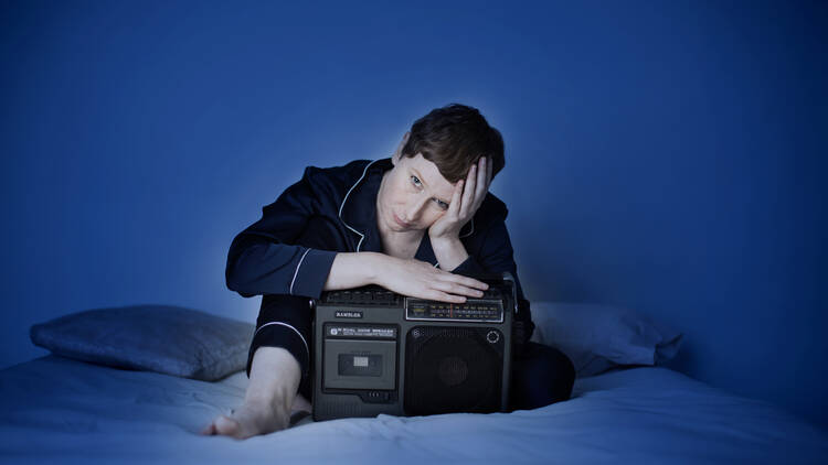 picture of a woman holding a radio struggling to sleep