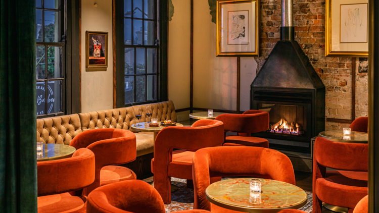 Orange chairs next to a fireplace