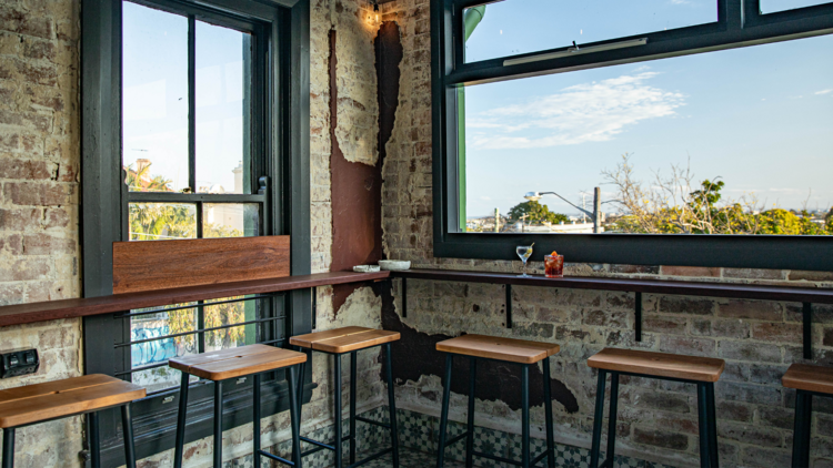 Bar stools in a corner overlooking a blue sky