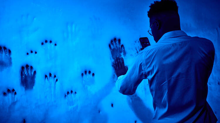 A person touching a wall of ice inside the exhibition. 