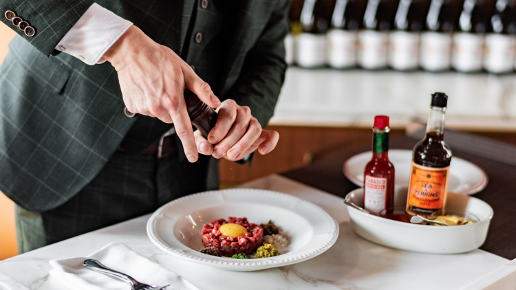 A waiter preparing the tartare at Charlotte Bar and Bistro