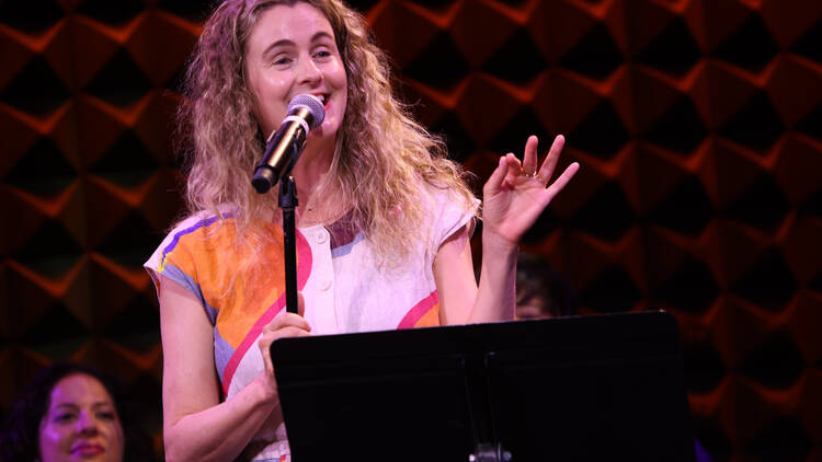 A woman speaks at a microphone.