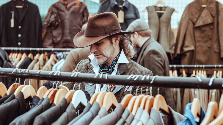 A man browsing a clothing rack. 