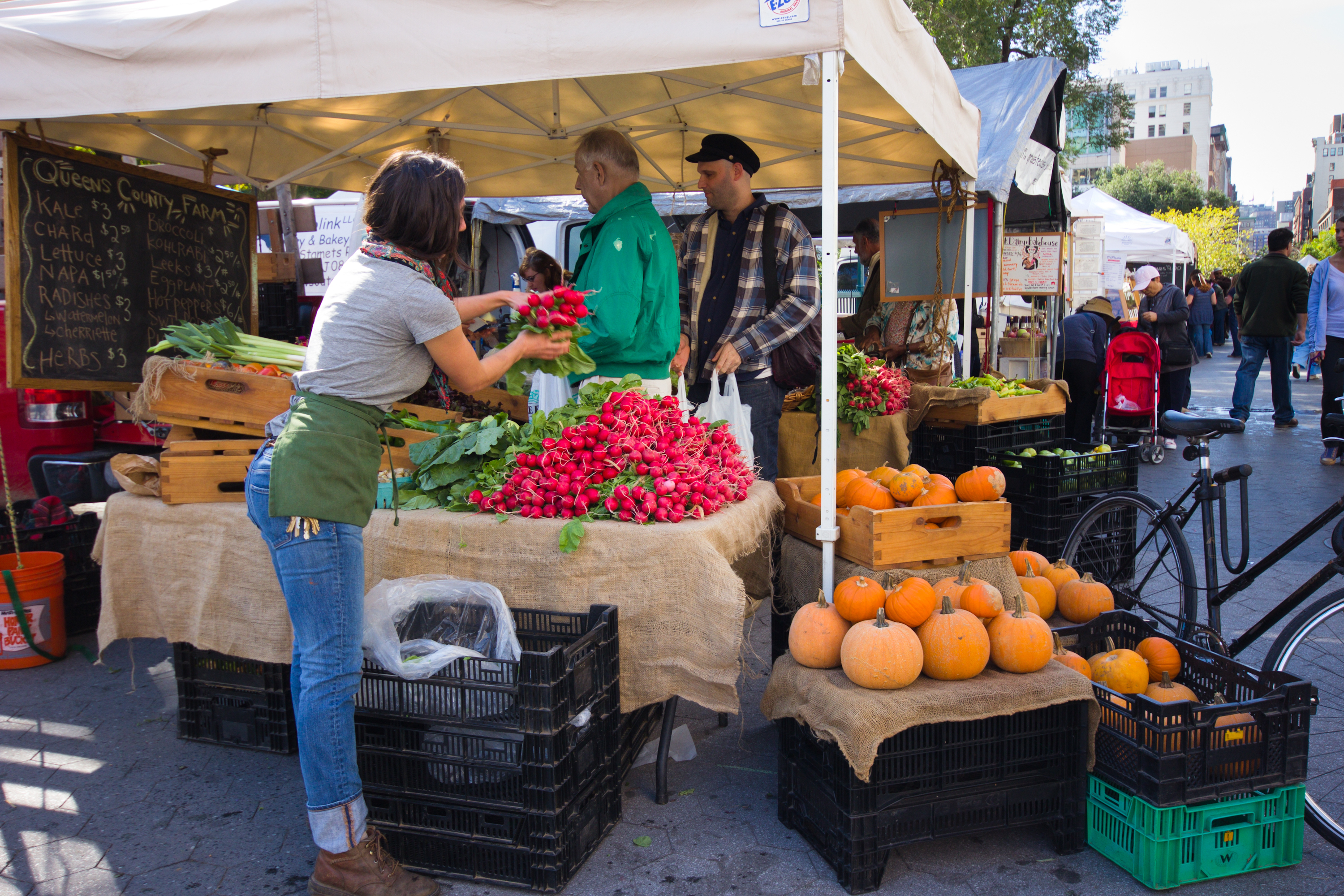 A woman sells radishes and pumpkins at the Union Square greenmarket.