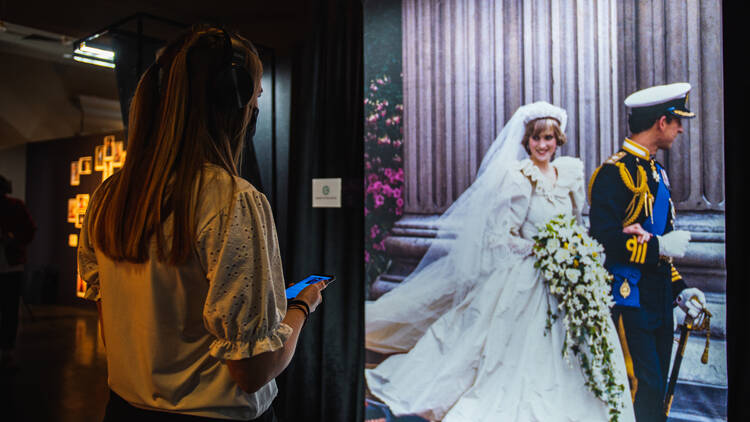 Picture of a girl on her phone at the immersive Princess Diana experience.