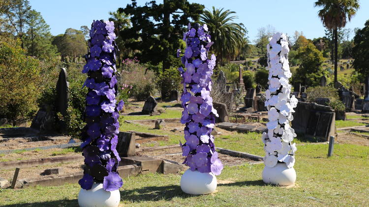 Purple and white flower sculptures in a cemetery