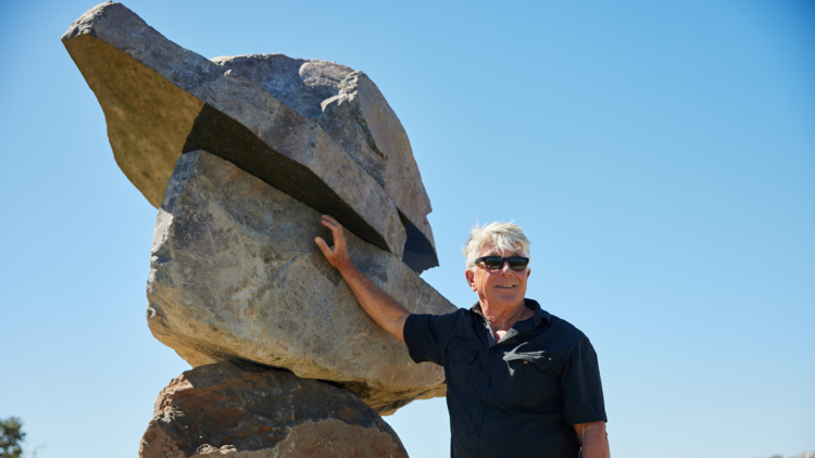 Artist John Petrie stands with '23.5°' at Sculpture by the Sea 2023