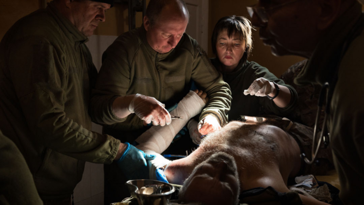 Doctors operating on a man in a dark room