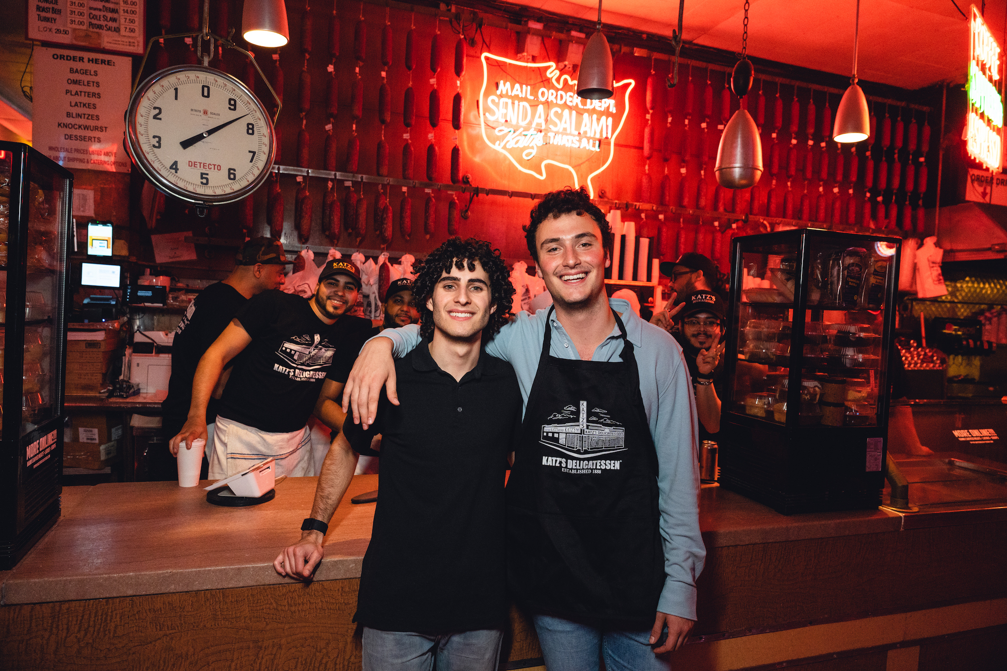 Two men stand in front of the counter at Katz's Deli.