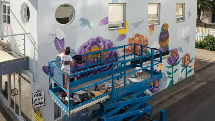 Lotte Smith and Styna on scaffold painting a mural