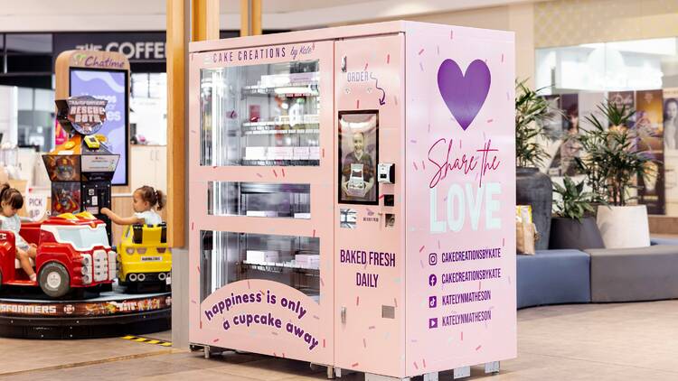 Pink cupcake vending machine in a shopping centre.