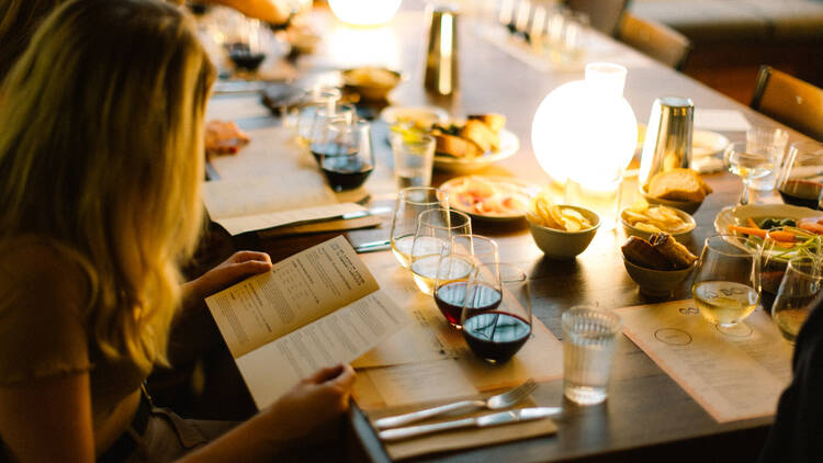 Woman reading an information card at a wine tasting event.