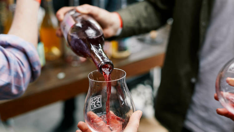 Man pouring wine into a tasting glass.