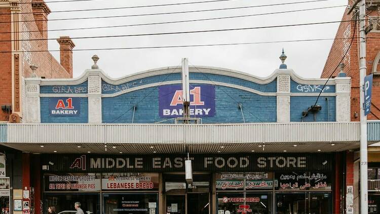 The exterior of a building that has signage that says: A1 Bakery, Middle East Food Store