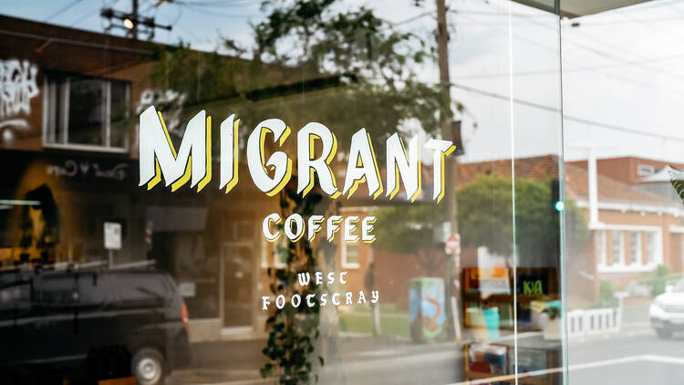 A shop window that has a sign that says Migrant Coffee, West Footscray