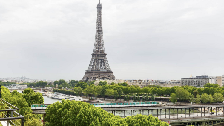 Spacious terrace at a Parisian Airbnb with a panoramic view of the Eiffel Tower.