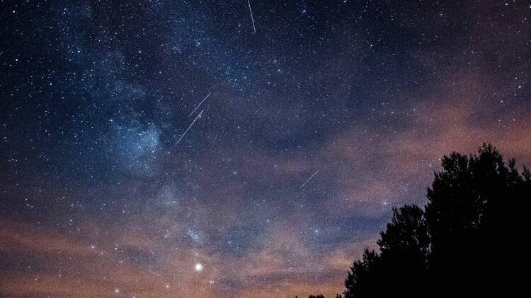 A meteor shower against a purply sky