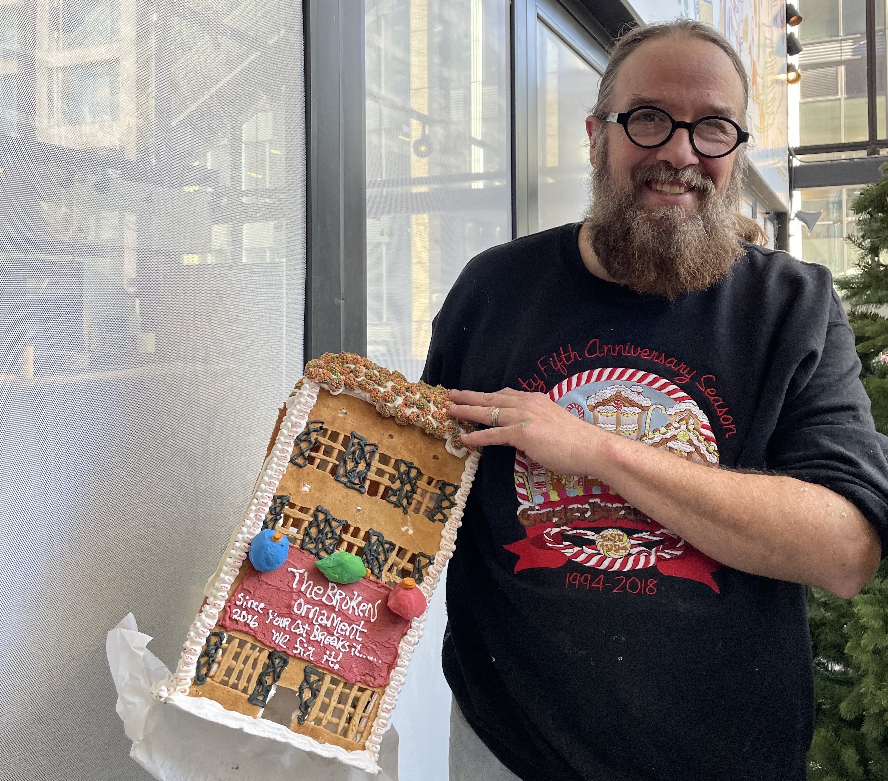 Jon Lovitch holds up a Gingerbread house.