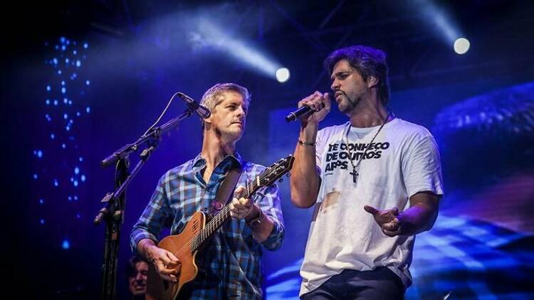 Victor e Leo cantam em um palco azulado