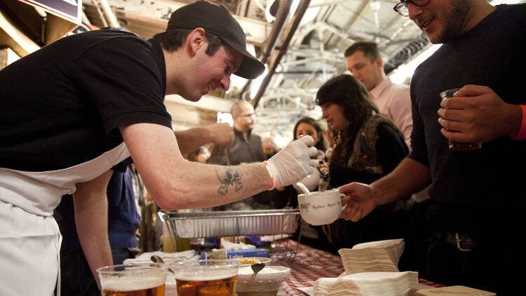 A chef serves chili to a customer.