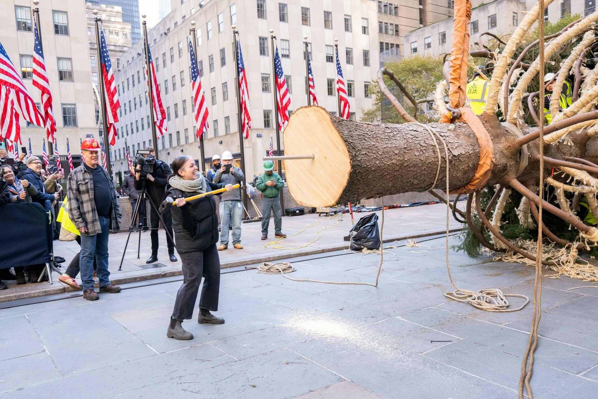 Jackie McGinley drives a spike into the trunk of the 2023 Rockefeller Center Christmas Tree