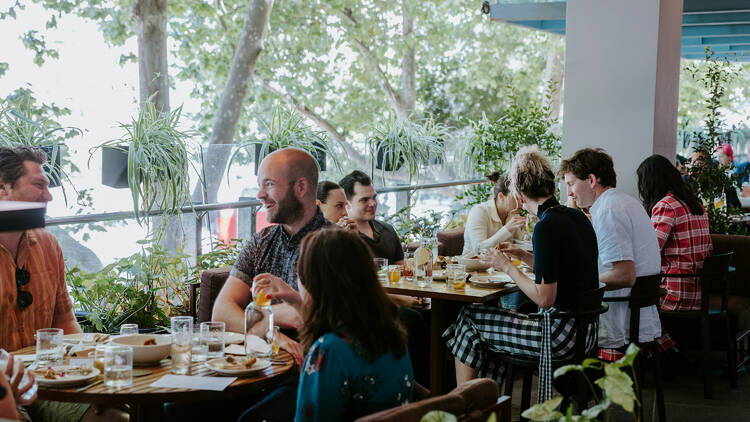 People gathered around a festive feast on the terrace at Victoria by Farmer's Daughters.