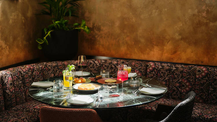 Assorted dishes and drinks laid out on a corner booth table at Pincho Disco.