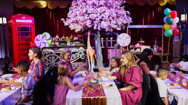 A Willy Wonka high tea with 2 mums and daughters dining at a table