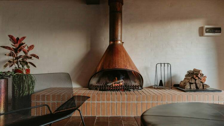 A room with a large copper fireplace.