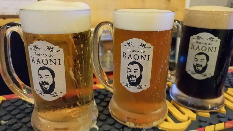 Três canecas de cerveja com a logo do Boteco do Raoni