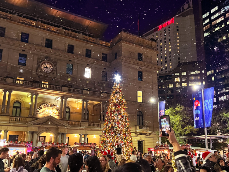 An outdoor Christmas market with a tree