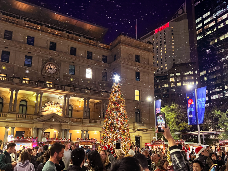 Wander under falling snow and fairy lights