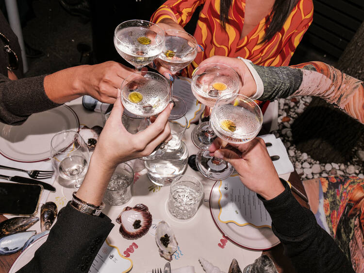 A group of people cheersing with cocktails.