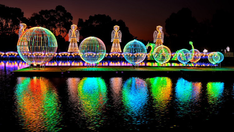 A Christmas lights display reflecting in water
