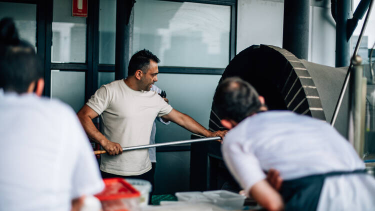 Chef cooking pizza in a pizza oven. 