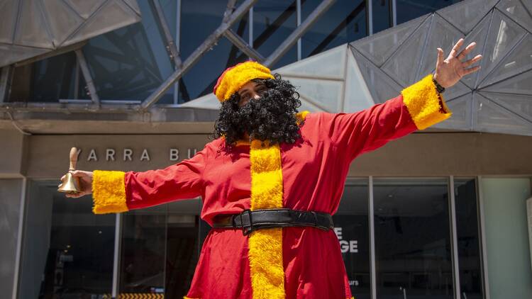 Koorie Klaus dressed in a red and yellow outfit. 